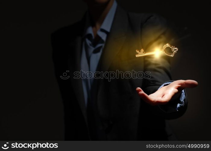 Key to success. Close up of human hand holding golden key