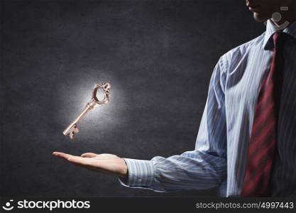 Key to success. Close up of human hand holding key symbol