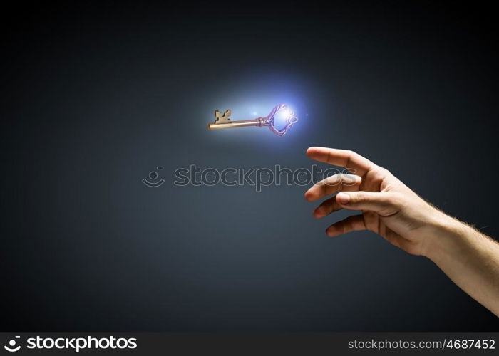 Key to success. Close up of human hand touching key