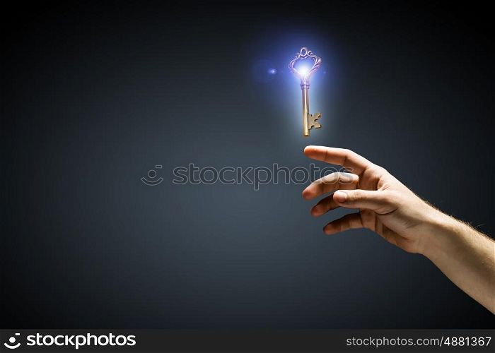 Key to success. Close up of human hand touching key