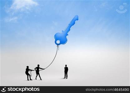 Key to success. Silhouettes of business people pulling key with rope