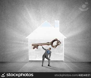 Key to success. Young businessman and lifting big key above head