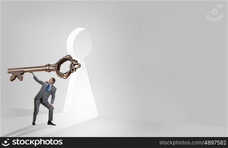 Key to success. Young businessman and lifting big key above head