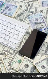 keyboard and modern phone with blank screen on money background. keyboard and phone