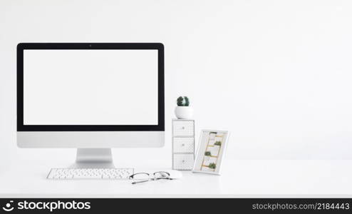 keyboard near monitor frame cactus eyeglasses table