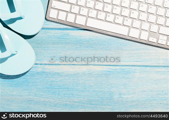 keyboard on beach table. white modern keyboard with beach accessories on blue wooden table