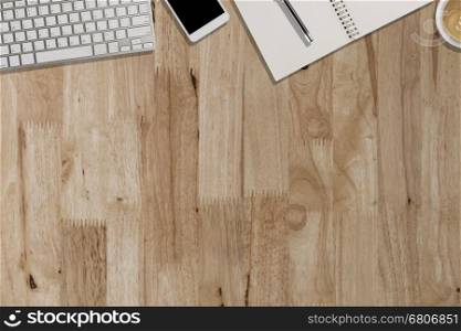 keyboard, smartphone, pen, notebook on wooden desk - top view with copy space