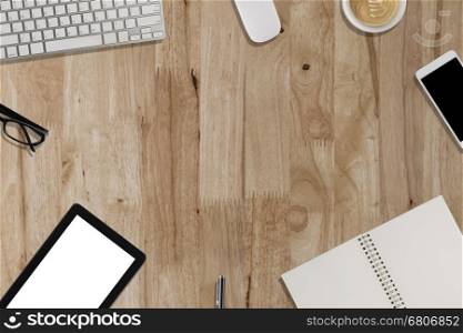 keyboard, smartphone, tablet, notebook on wooden desk - top view with copy space