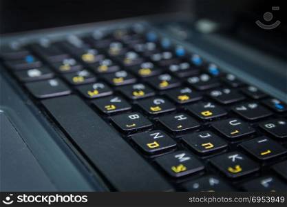 Keyboard with letters in Hebrew and English - Laptop keyboard - Close up - Dark atmosphere