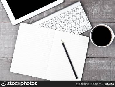 Keyboard with pencil and coffee cup and tablet on office desk