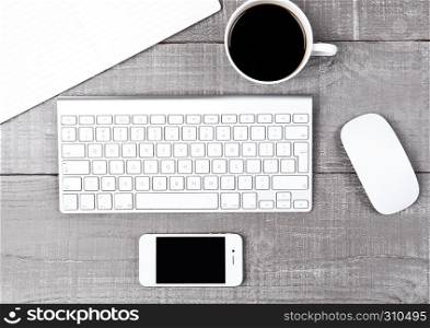 Keyboard with phone coffee cup and mouse on office desk