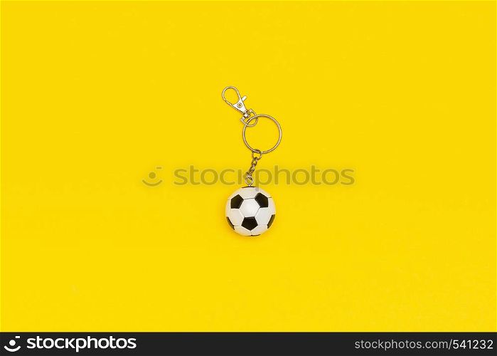 Keychain with soccer or football ball on yellow background in minimal style. Top view Copy space Template for text or your design.. Keychain with soccer or football ball on yellow background in minimal style. Top view Copy space Template for text or your design