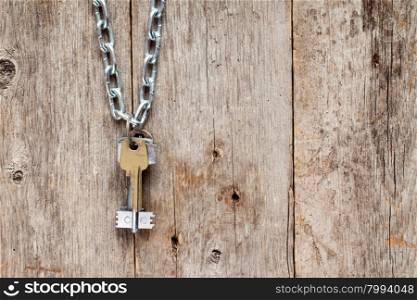 Keys hanging on chain against old wooden wall