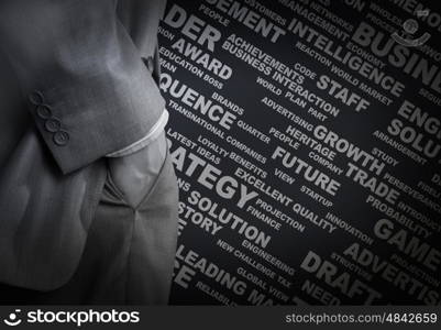 Keywords of business. Bottom view of businessman with hands in pockets