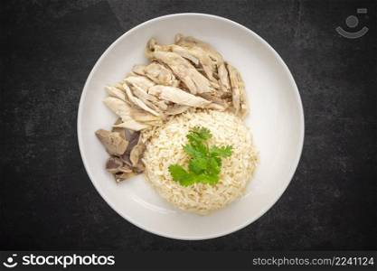 Khao Mun Gai, Thai food, rice steamed with chicken soup serve with chicken, soup and sauce on dark tone texture background, top view