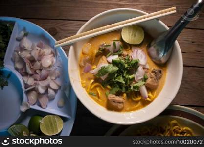 Khao soi - Traditional Thai Food, Khao Soi Thai Noodle Curry Soup with chicken on wood table