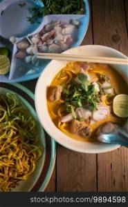Khao soi - Traditional Thai Food, Khao Soi Thai Noodle Curry Soup with chicken on wood table