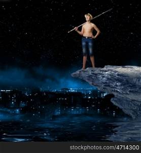 Kid fisherman. Young boy at night with fishing rod