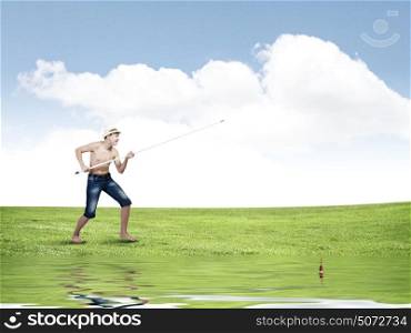 Kid fisherman. Young boy fishing with rod on lake bank