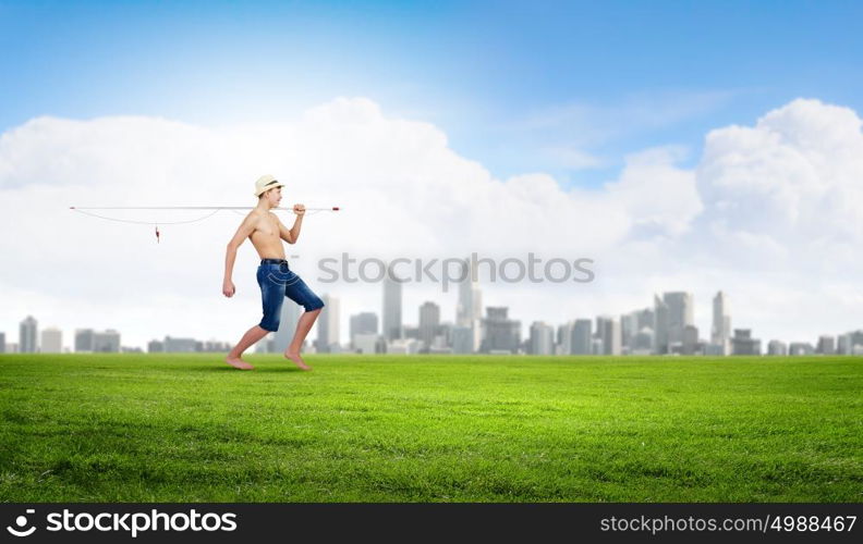 Kid fisherman. Young boy walking with fishing rod on shoulder