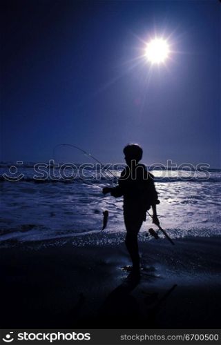 kid fishing at the beach