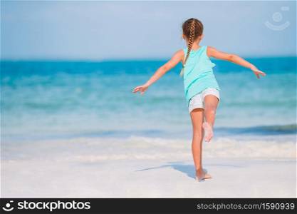 Kid fun. Little girl on the beach walking and playing. Cute little girl at beach during caribbean vacation