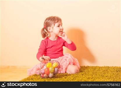 Kid gathers colorful eggs to the baskets on Easter Egg hunt. Girl on an Easter Egg hunt