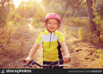 kid girl biker in mountain bike MTB at mediterranean forest