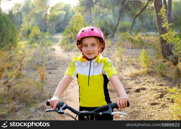 kid girl biker in mountain bike MTB at mediterranean forest