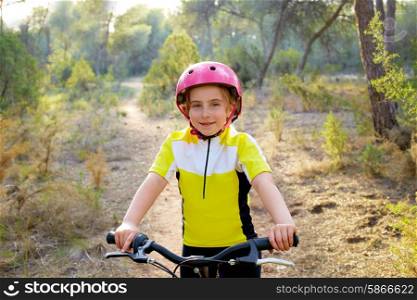 kid girl biker in mountain bike MTB at mediterranean forest