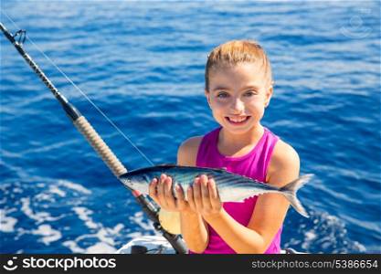 kid girl fishing tuna bonito sarda fish happy with trolling catch on boat deck