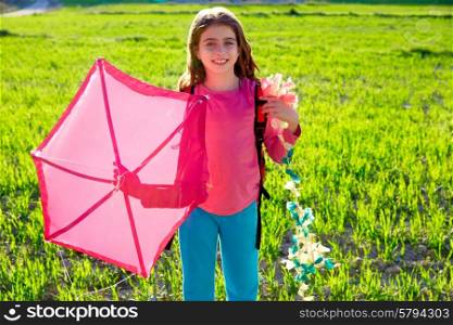 Kid girl holding pink kite traditional in spring on meadow