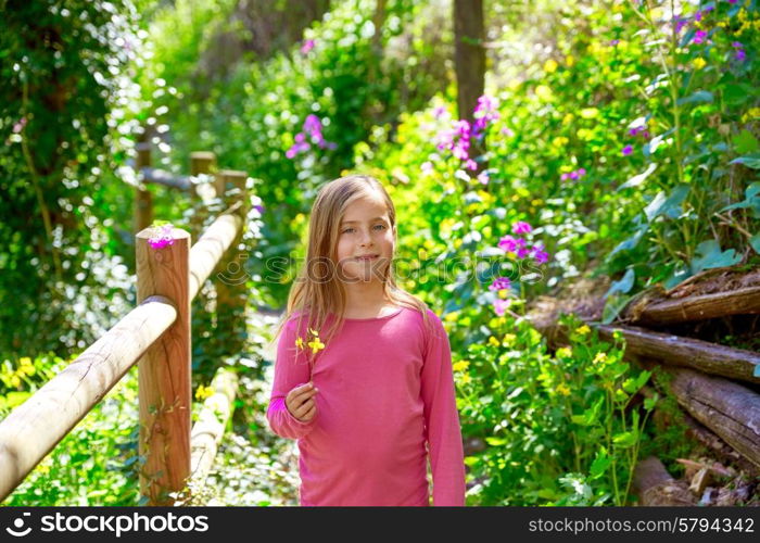 kid girl in spring track in Cuenca forest of Spain with wooden fence