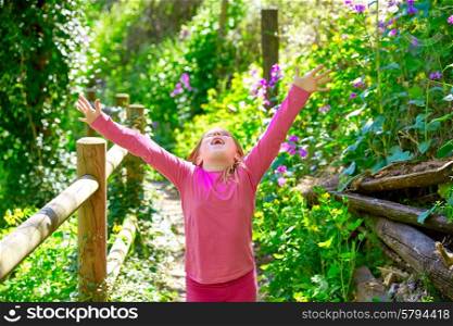 kid girl in spring track in Cuenca forest of Spain with wooden fence