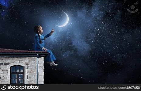 Kid girl on roof. Little girl sitting house roof and pointing with finger on moon