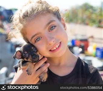 kid girl playing with puppy dog smiling with blue eyes