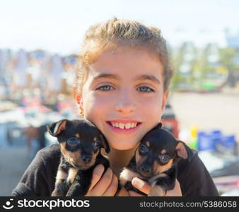 kid girl playing with puppy dogs smiling with blue eyes