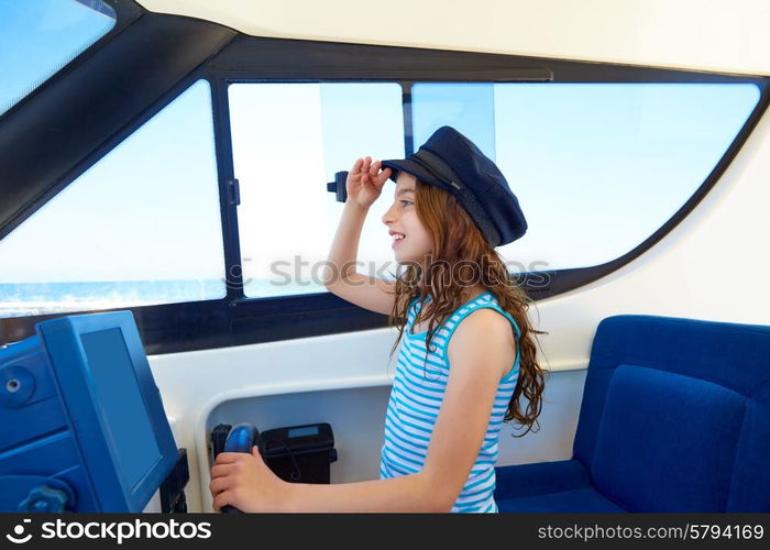 Kid girl pretending be a captain sailor cap in boat indoor holding wheel