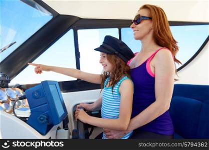Kid girl pretending be a captain sailor cap with her mother in boat indoor