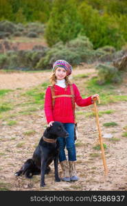 Kid girl shepherdess happy with dog flock of sheep and wooden stick in Spain