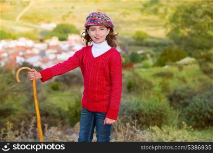 Kid girl shepherdess smiling with wooden baston in Spain village