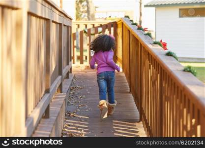kid girl toddler playing running in park rear view latin ethnicity