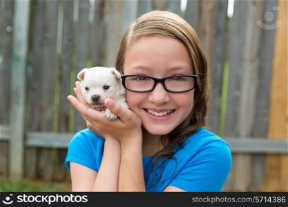 kid girl with puppy pet chihuahua playing happy with doggy outdoor