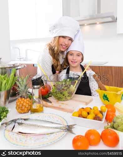 Kid girls junior chef friends hug together in countertop with food at cooking school