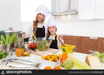 Kid girls junior chef friends hug together in countertop with food at cooking school