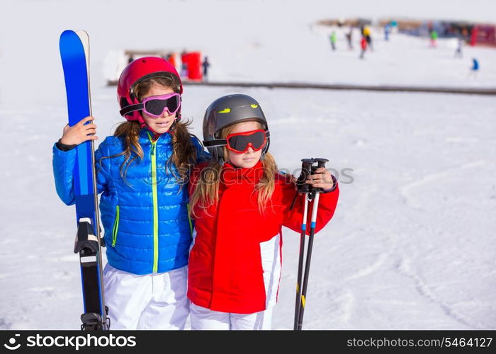 Kid girls sister in winter snow with ski equipment helmet goggles poles