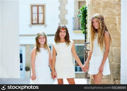 Kid girls walking hand in hand at white Mediterranean village of Spain