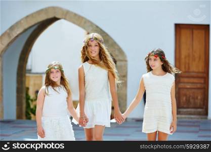 Kid girls walking hand in hand at white Mediterranean village of Spain