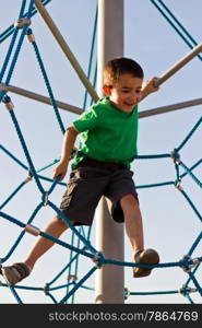 Kid having fun on the jungle gym at the playground