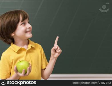 kid holding apple while pointing up